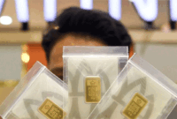 Pramuniaga menunjukkan emas batangan di sebuah gerai penjualan emas di Samarinda, Kalimantan Timur, Rabu (14/1/2026). Berdasarkan situs Logam Mulia Antam pada Rabu (14/1), harga emas Antam sejak 10 Januari 2026 naik beruntun sebesar Rp13.000 dari semula Rp2.652.000 menjadi Rp2.665.000 per gramnya dan kenaikan harga tersebut menjadi rekor harga tertinggi sepanjang masa. ANTARA FOTO/M Risyal Hidayat/YU (ANTARA FOTO/M RISYAL HIDAYAT)