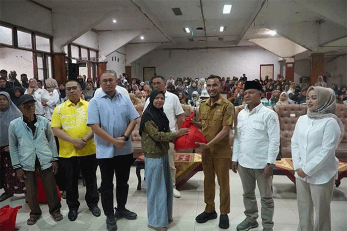 Seorang warga Padang Panjang ketika menerima paket sembako yang disalurkan Anggota DPR-RI, Andre Rosiade.