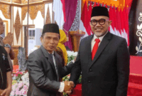 Asisten Perekonomian dan Pembangunan Kota Sungai Penuh, Nasran, S.E., M.Si, memberikan selamat kepada Dr. H. Sudirman, S.H., M.H. sebagai Komisaris Utama Bank Jambi di Auditorium Rumah Dinas Gubernur Jambi