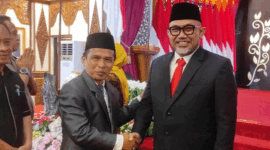 Asisten Perekonomian dan Pembangunan Kota Sungai Penuh, Nasran, S.E., M.Si, memberikan selamat kepada Dr. H. Sudirman, S.H., M.H. sebagai Komisaris Utama Bank Jambi di Auditorium Rumah Dinas Gubernur Jambi