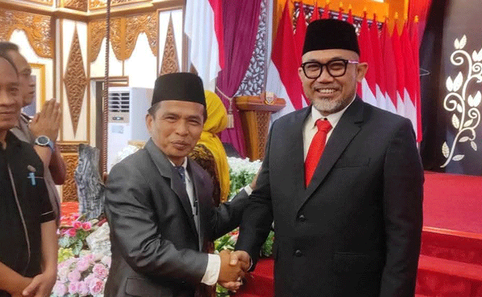 Asisten Perekonomian dan Pembangunan Kota Sungai Penuh, Nasran, S.E., M.Si, memberikan selamat kepada Dr. H. Sudirman, S.H., M.H. sebagai Komisaris Utama Bank Jambi di Auditorium Rumah Dinas Gubernur Jambi