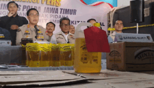 Humas Polda Jatim, Kombes Pol Jules Abraham Abast, serta Direktur Reserse Kriminal Khusus Polda Jatim Kombes Pol Roy Hutton Marulamrata Sihombing, bersama barang bukti Minyakita ilegal, Selasa, (21/04/2026)(KOMPAS.com/JACK ROBBY DAMARJATI)