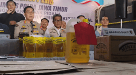 Humas Polda Jatim, Kombes Pol Jules Abraham Abast, serta Direktur Reserse Kriminal Khusus Polda Jatim Kombes Pol Roy Hutton Marulamrata Sihombing, bersama barang bukti Minyakita ilegal, Selasa, (21/04/2026)(KOMPAS.com/JACK ROBBY DAMARJATI)