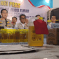 Humas Polda Jatim, Kombes Pol Jules Abraham Abast, serta Direktur Reserse Kriminal Khusus Polda Jatim Kombes Pol Roy Hutton Marulamrata Sihombing, bersama barang bukti Minyakita ilegal, Selasa, (21/04/2026)(KOMPAS.com/JACK ROBBY DAMARJATI)