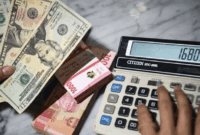 Petugas menunjukkan pecahan mata uang dolar Amerika Serikat dan mata uang Rupiah di Kantor Cabang BNI Pasar Baru, Jakarta, Selasa (10/3/2026). ANTARA FOTO/Muhammad Adimaja/rwa. (ANTARA FOTO/MUHAMMAD ADIMAJA)