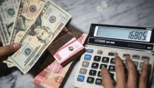 Petugas menunjukkan pecahan mata uang dolar Amerika Serikat dan mata uang Rupiah di Kantor Cabang BNI Pasar Baru, Jakarta, Selasa (10/3/2026). ANTARA FOTO/Muhammad Adimaja/rwa. (ANTARA FOTO/MUHAMMAD ADIMAJA)