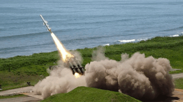ilustrasi gambar Peluncuran rudal dari kendaraan militer di area pesisir