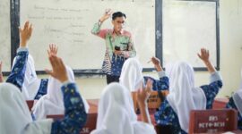 guru yang sedang mengajar di kelas