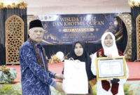 Wakil Wali Kota Azhar Hamzah menyerahkan piagam penghargaan kepada siswi berprestasi yang berhasil menyelesaikan hafalan sebanyak 27 juz Al-Qur’an.