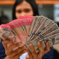 Karyawan memperlihatkan uang pecahan rupiah dan dolar Amerika Serikat (AS) di gerai penukaran mata uang asing Ayu Masagung, Jakarta, Selasa (12/5/2026). Foto: Indrianto Eko Suwarso/ANTARA FOTO