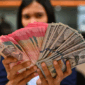 Karyawan memperlihatkan uang pecahan rupiah dan dolar Amerika Serikat (AS) di gerai penukaran mata uang asing Ayu Masagung, Jakarta, Selasa (12/5/2026). Foto: Indrianto Eko Suwarso/ANTARA FOTO