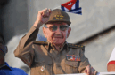 Mantan Presiden Kuba Raul Castro mengibarkan bendera nasional Kuba dalam peringatan Hari Buruh Internasional (May Day) di Alun-Alun Revolusi Havana, Kuba (1/5/2025). Foto: Yamil Lage/AFP