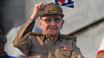 Mantan Presiden Kuba Raul Castro mengibarkan bendera nasional Kuba dalam peringatan Hari Buruh Internasional (May Day) di Alun-Alun Revolusi Havana, Kuba (1/5/2025). Foto: Yamil Lage/AFP