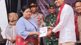 Kepala OJK Provinsi Jambi, Yan Iswara Rosya menyerahkan bantuan simbolis pembukaan tabungan Bank Jambi bagi perempuan Suku Anak Dalam