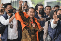 Petugas kepolisian menggiring Roy Suryo (tengah) ke dalam gedung di Kejaksaan Negeri Jakarta Selatan, Jakarta, Senin (22/6/2026). Foto: Sulthony Hasanuddin/Antara Foto