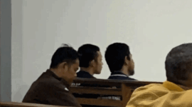Dua terdakwa kasus rudapaksa di Padepokan Silat DPMA, Husni Mubarok dan Heri, saat duduk menjelang sidang pemeriksaan saksi. Keduanya dikeluarkan dari ruang sidang tertutup di Pengadilan Negeri Jambi