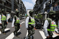 Petugas polisi militer bersiap untuk latihan tentang cara membimbing warga ke tempat yang aman jika terjadi serangan, di Taipei, Taiwan. Foto: Ann Wang/REUTERS