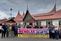 Warga Pandai Sikek, Kabupaten Ta ah Datar membenta gkan spanduk bertuliskan menolak jalan tol.