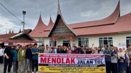 Warga Pandai Sikek, Kabupaten Ta ah Datar membenta gkan spanduk bertuliskan menolak jalan tol.