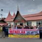 Warga Pandai Sikek, Kabupaten Ta ah Datar membenta gkan spanduk bertuliskan menolak jalan tol.