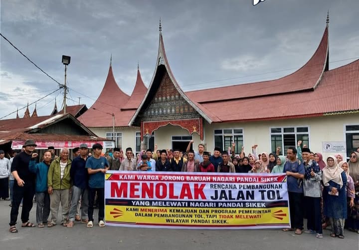 Warga Pandai Sikek, Kabupaten Ta ah Datar membenta gkan spanduk bertuliskan menolak jalan tol.