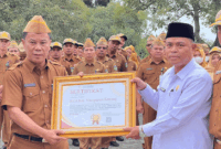 Sekda Alpian menyerahkan sertifikat penghargaan kepada Kantor Urusan Agama (KUA) Kecamatan Hamparan Rawang
