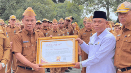 Sekda Alpian menyerahkan sertifikat penghargaan kepada Kantor Urusan Agama (KUA) Kecamatan Hamparan Rawang