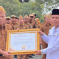 Sekda Alpian menyerahkan sertifikat penghargaan kepada Kantor Urusan Agama (KUA) Kecamatan Hamparan Rawang