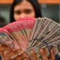 Karyawan memperlihatkan uang pecahan rupiah dan dolar Amerika Serikat (AS) di gerai penukaran mata uang asing Ayu Masagung, Jakarta, Selasa (12/5/2026)