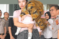Femi (27) memeluk anak kandung perempuannya yang berusia delapan bulan di Mapolda Jambi, Rabu (29/7/2026). Sang bayi bisa kembali setelah dijual ayah kandungnya, Tedi (27). (TRIBUN JAMBI/RIFANI HALIM) 