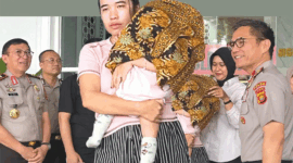 Femi (27) memeluk anak kandung perempuannya yang berusia delapan bulan di Mapolda Jambi, Rabu (29/7/2026). Sang bayi bisa kembali setelah dijual ayah kandungnya, Tedi (27). (TRIBUN JAMBI/RIFANI HALIM) 