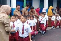 Anak-anak disambut para guru hari pertama masuk sekolah