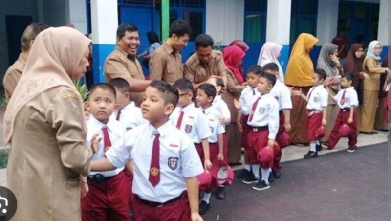 Anak-anak disambut para guru hari pertama masuk sekolah