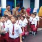 Anak-anak disambut para guru hari pertama masuk sekolah