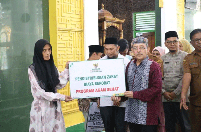 Ketua Baznas Agam Isman Imran menyerahkan zakat, infak dan sedekah kepada mustahik. ANTARA/HO/Baznas Agam