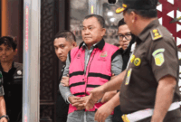 Tersangka dugaan tindak pidana korupsi tata kelola program Makan Bergizi Gratis (MBG) pada Badan Gizi Nasional (BGN) Lodewyk Pusung (tengah) berjalan memasuki mobil tahanan di Kejaksaan Agung