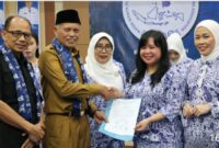Wawako Azhar Hamzah, dampingi Ny Sri Kartini Alfin dan Ny Mawarti Azha, menyaksikan penyerahan SK Pelantikan kepada  Ny Syuhada Ketua IWAPI Kota Sungai Penuh dan Kerua IWAPI Provinsi Jambi Ny Haslins.