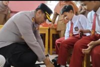 Kepedulianan Kapolres Kerinci AKBP Ramadhani,S.H., S.I.K, langsung memasangkan Sepada bantuan pada Anak didik SD 023/11 Aurduri Sungai Penuh.