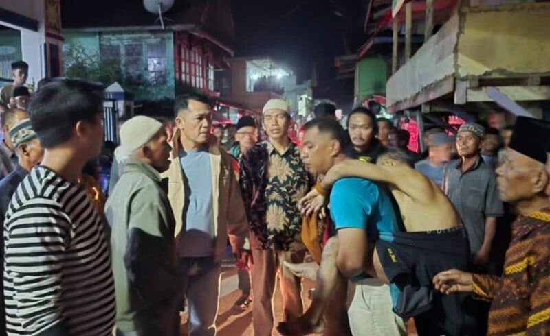 Warga Desa Sungai Deras Bersama Polisi Mengevakuasi Suami Korban.