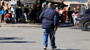 Seorang petugas polisi berjalan di lokasi penembakan di Lwandle, Western Cape, Afrika Selatan, Minggu (27/9/2026). Foto: Esa Alexander/REUTERS