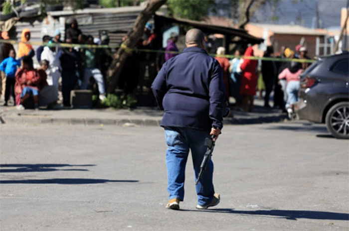 Seorang petugas polisi berjalan di lokasi penembakan di Lwandle, Western Cape, Afrika Selatan, Minggu (27/9/2026). Foto: Esa Alexander/REUTERS