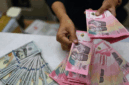Karyawan menghitung uang pecahan rupiah dan dolar Amerika Serikat (AS) di gerai penukaran mata uang asing Ayu Masagung, Jakarta, Selasa (12/5/2026).