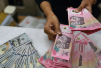 Karyawan menghitung uang pecahan rupiah dan dolar Amerika Serikat (AS) di gerai penukaran mata uang asing Ayu Masagung, Jakarta, Selasa (12/5/2026).