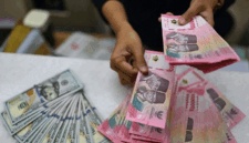 Karyawan menghitung uang pecahan rupiah dan dolar Amerika Serikat (AS) di gerai penukaran mata uang asing Ayu Masagung, Jakarta, Selasa (12/5/2026).