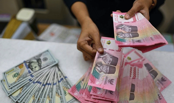 Karyawan menghitung uang pecahan rupiah dan dolar Amerika Serikat (AS) di gerai penukaran mata uang asing Ayu Masagung, Jakarta, Selasa (12/5/2026).