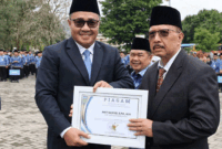 Wali Kota Sungai Penuh Alfin menyerahkan piagam penghargaan kepada ASN purna tugas di halaman Kantor Wali Kota Sungai Penuh.