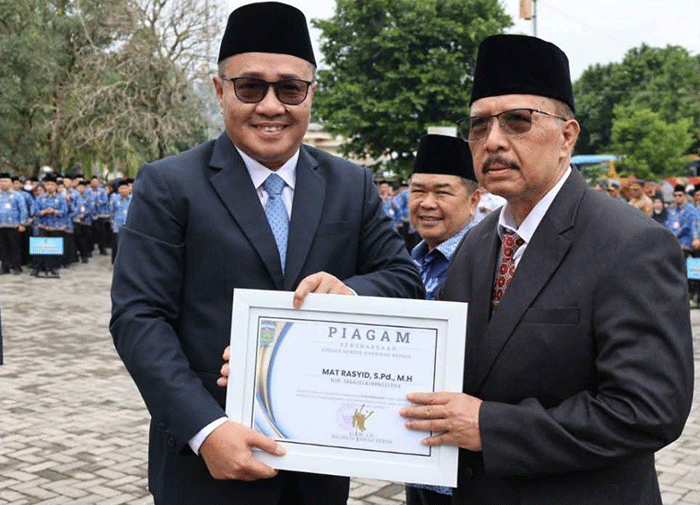 Wali Kota Sungai Penuh Alfin menyerahkan piagam penghargaan kepada ASN purna tugas di halaman Kantor Wali Kota Sungai Penuh.