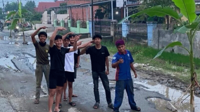 Pemuda setempat menanam pisang di tengah jalan sebagai bentuk protes.